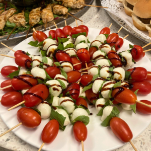 Caprese skewers served at Reston National Golf Course, featuring cherry tomatoes, fresh mozzarella, and basil drizzled with balsamic glaze on a platter for events and gatherings.