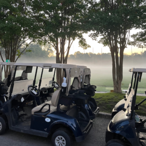 Golf carts lined up at Reston National Golf Course for a tournament, with early morning fog creating a scenic atmosphere.