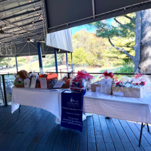 Display of auction items at Reston National Golf Course during a golf outing fundraiser, featuring various prizes and merchandise arranged on tables for bidding