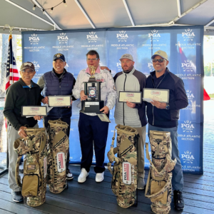 PGA HOPE foursome at Reston National Golf Course holding their trophies and new golf bags after winning their tournament, smiling and celebrating on the course.