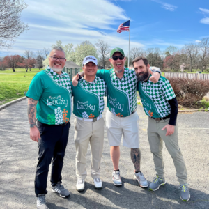 Foursome of golfers wearing matching shirts at Reston National Golf Course for the Shamrock Scramble, posing together before their round.